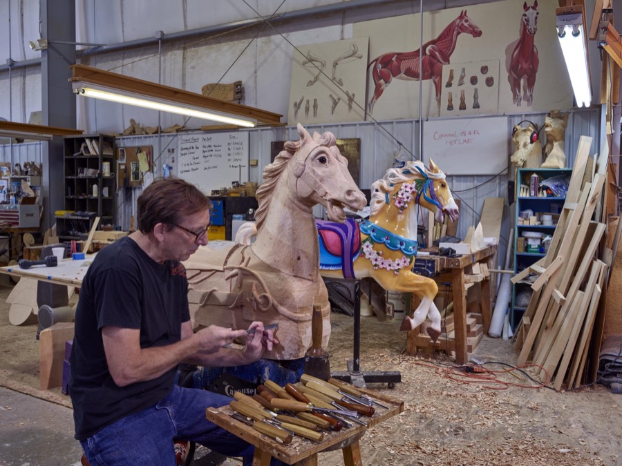 In Mansfield, Ohio artisan Tim Gorka chisels a detail on a wooden horse at the Carousel Works, the world's largest maker of carousels, sometimes called "merry-go-rounds"