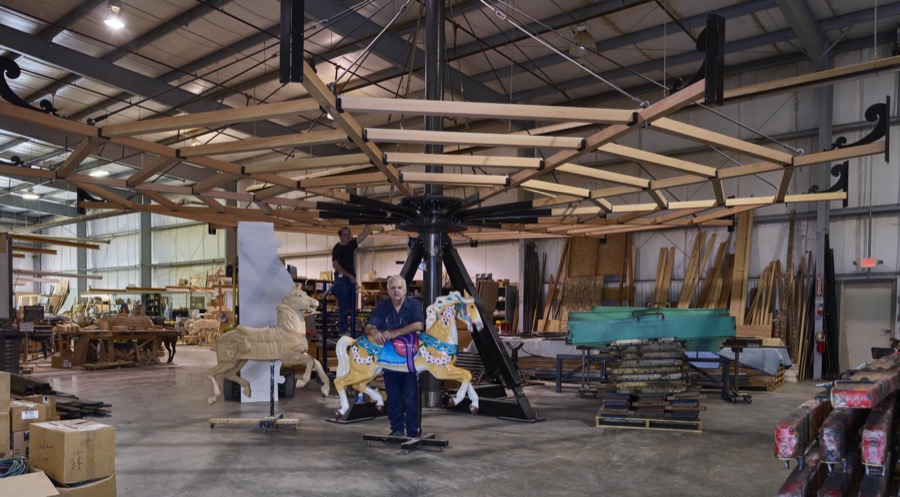 In Mansfield, Ohio, artisan Tim Gorka (on the ladder) and co-owner Art Ritchie stand beneath the ribs of a carousel under construction at the Carousel Works, the world's largest maker of carousels, sometimes called "merry-go-rounds"