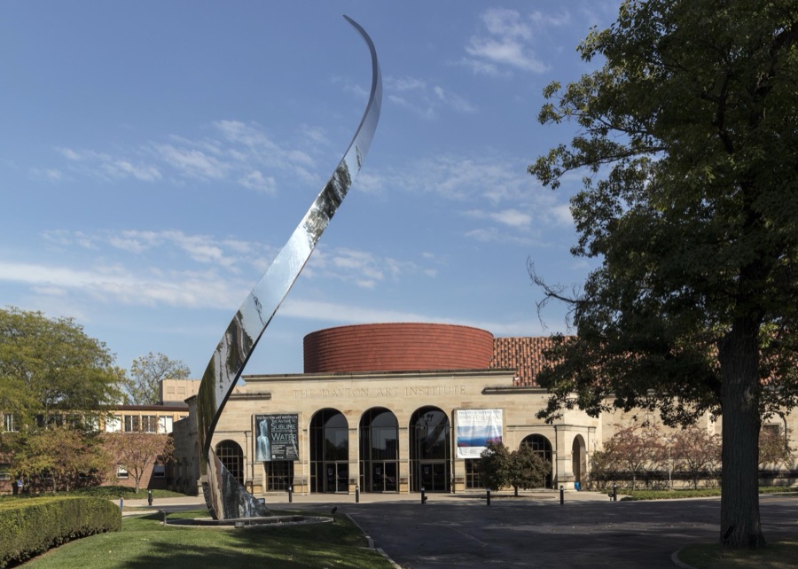 Artist John Safer's stainless-steel "Pathway" sculpture, dedicated to "the spirit of [Dayton aviation pioneers] Orville and Wilbur Wright," casts a striking contrast to the 1930 Edward B. Green Building that houses the Dayton Art Institute, a museum of fine arts in Dayton, Ohio
