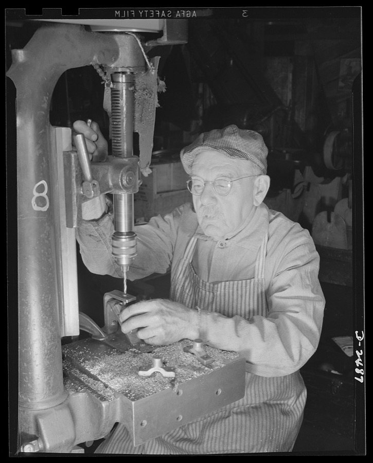 Conversion. Food machinery plant. Back to aid in his country's war effort is Phineas Davenport Allen, seventy-eight-year-old mechanic who worked on steering riggings for submarines during World War I. Today he is employed by a New England company, whose normal peacetime product is cube steak machinery. The drill press he operates was a valuable part of the company's peacetime equipment, is even more valuable today in the speeding of work on war subcontracts. Here Allen is drilling bearing caps for cube steak machines. Cube Steak Machine Company, Boston, Massachusetts