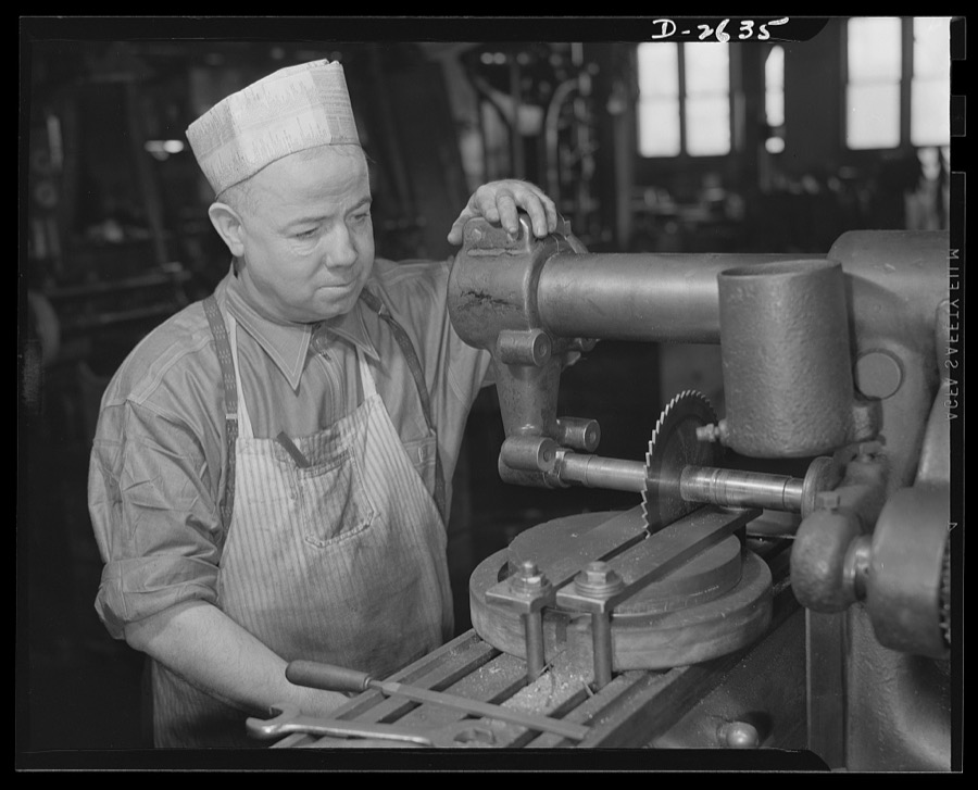 Conversion. Food machinery plant. Operator of this universal milling machine is John J. Morris, shown here cutting steel disk covers for his company's normal product--cube steak machines. Today Morris uses the same machine adapted to war subcontract work --cutting of large hexagonal nuts for a government arsenal. "Hexing a nut" is a very simple job with a machine designed to shape the entire nut in one operation, but this machine is not available and time is short. Morris, therefore, turns the round steel stock three times, cutting two sides at a time
