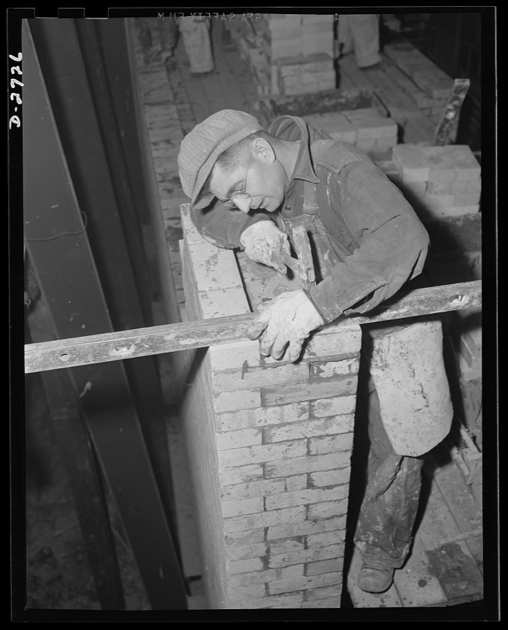 Fiberglass manufacture, Owens-Corning, Toledo, Ohio. To increase productive capacity and meet war demands for fiberglass thermal and acoustical insulation, workmen in a plant of the Owens-Corning Fiberglass Corporation are laying firebrick. This is the first step in the construction of one of the huge furnaces required for glass-melting