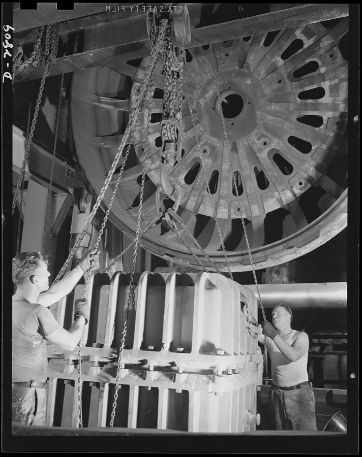 Conversion. Tire plant. This vulcanizing unit, largest in the world, was designed for the vulcanizing of giant tires used on earth-moving machinery, but is now helping out the war program by vulcanizing self-sealing gas tanks for the nation's war planes. The special mold containing the tank is being lowered into position in the tire vulcanizing unit. When it is in place, the huge cover of the unit will be lowered into position and closed. The heat will then be turned on to cure the raw rubber of the gas tank