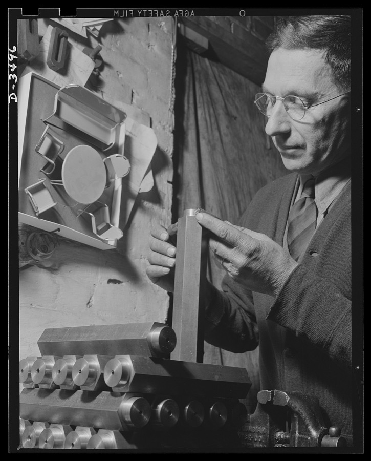 Conversion. Toy furniture to dies for incendiary bombs. Dies to destroy the Axis. The owner of this small Midwest factory inspects dies for making incendiary bombs. Note doll's furniture on the wall, the company's previous product. Complete conversion of all machines for this factory's production of war essentials is rapidly taking place. Sivon Machine Company, Painesville, Ohio