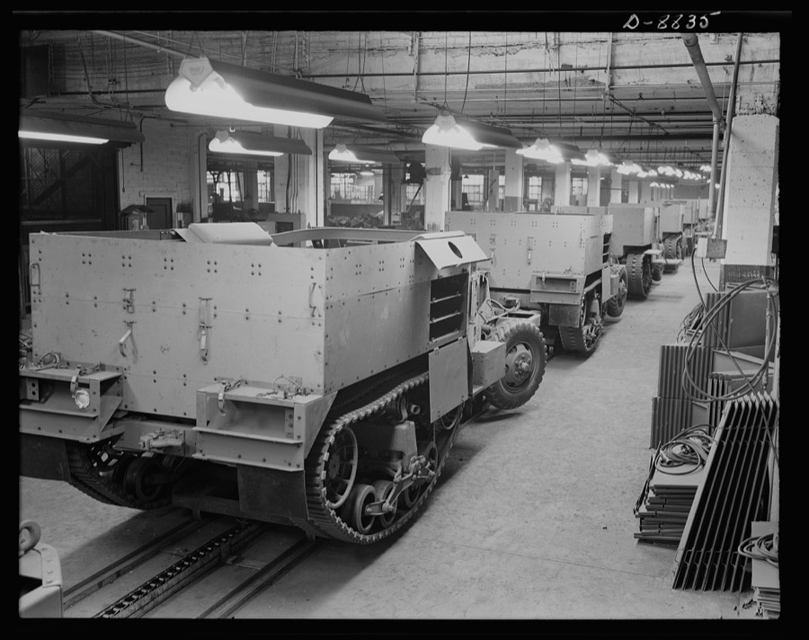 Production. Halftrac armoured cars. Partly finished halftrac scout cars travel along a moving assembly line in a plant converted from the manufacture of safes and locks. The bodies are made in this plant and mounted on chassis produced in a converted automobile plant. Diebold Safe and Lock Company, Canton, Ohio